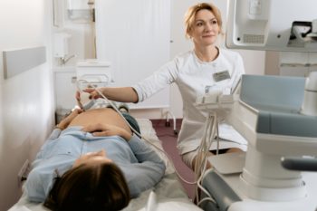 Szülész-nőgyógyász ultrahanggal vizsgál egy várandós nőt